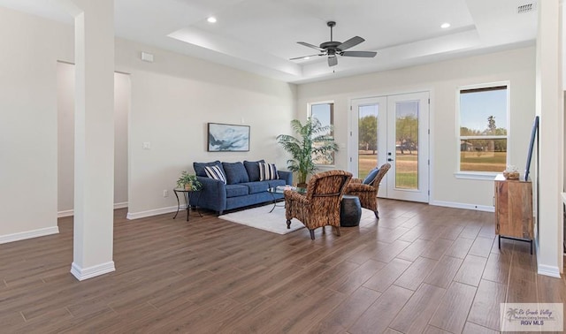 living area with visible vents, a raised ceiling, french doors, baseboards, and dark wood-style flooring