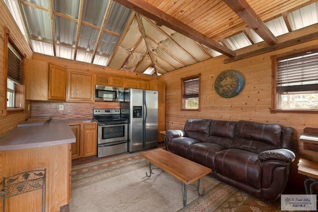 carpeted living room with vaulted ceiling with beams and wood walls