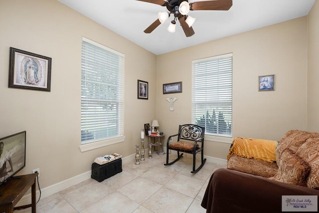 living area featuring light tile patterned floors and ceiling fan