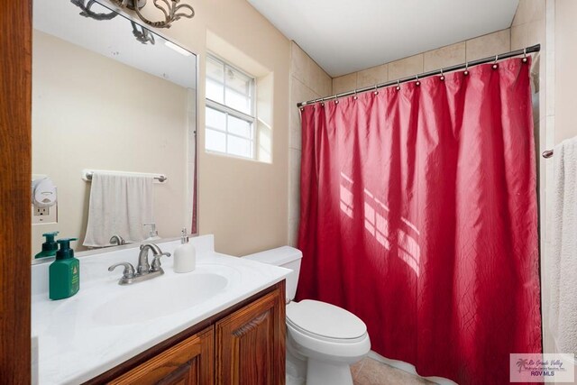 bathroom featuring tile patterned floors, vanity, toilet, and walk in shower