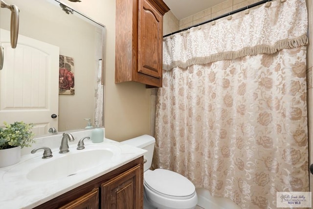 bathroom featuring curtained shower, vanity, and toilet