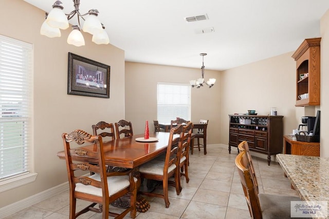 tiled dining area with a chandelier