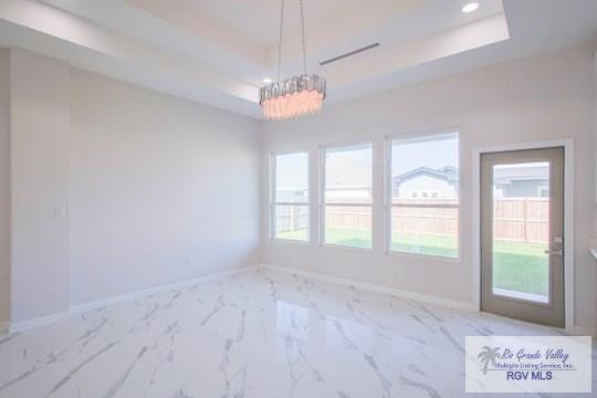 interior space with an inviting chandelier and a raised ceiling