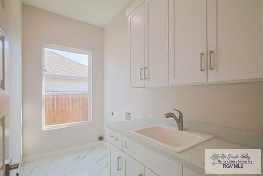 washroom featuring cabinets, hookup for a washing machine, and sink