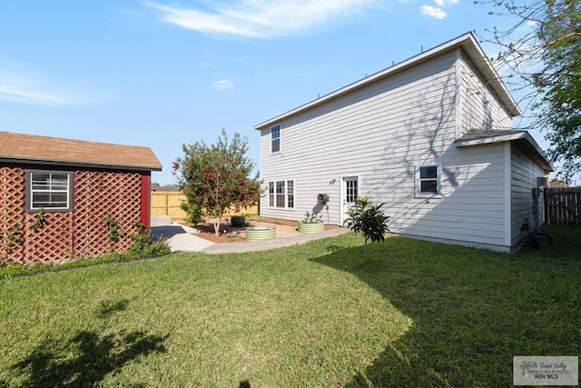 rear view of house with a lawn and fence