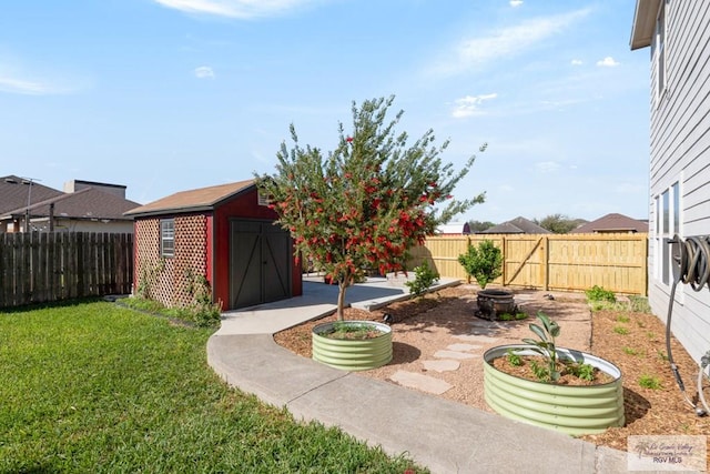 view of yard with a storage unit, an outbuilding, a fire pit, and a fenced backyard