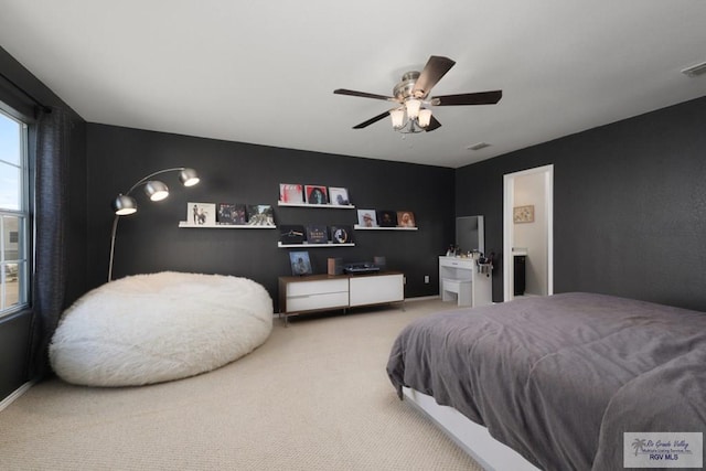 carpeted bedroom with visible vents and a ceiling fan