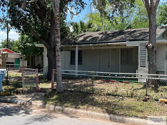 610 Charlotte St, San Benito, TX 78586 - view of front of property with covered porch, a fenced front yard, and roof with shingles
