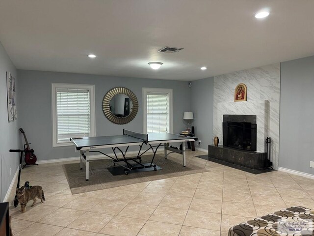 recreation room with a tile fireplace and light tile patterned floors