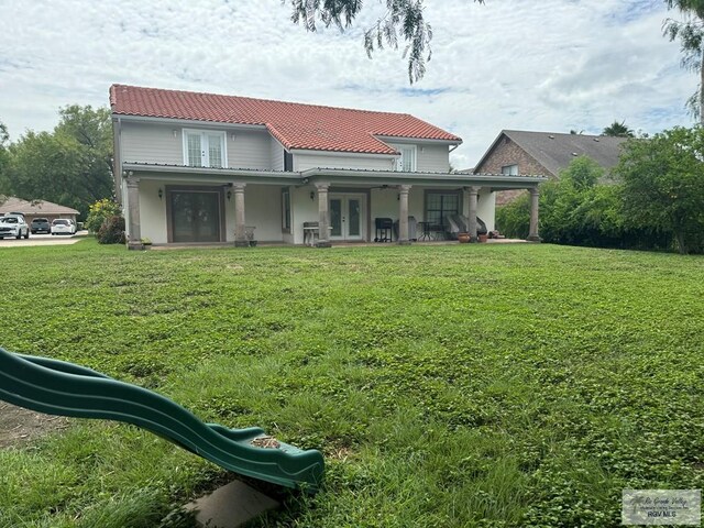 rear view of property featuring a yard and french doors