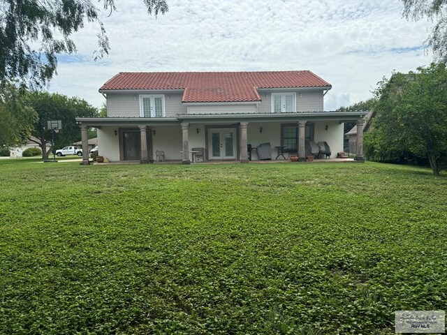 rear view of house with french doors, a yard, and a patio