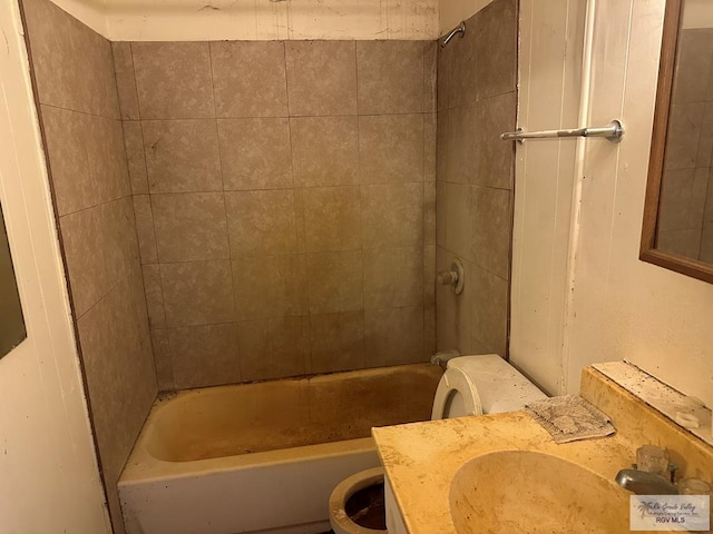 full bathroom with tiled shower / bath, vanity, and toilet