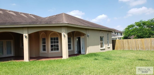 rear view of house featuring a lawn