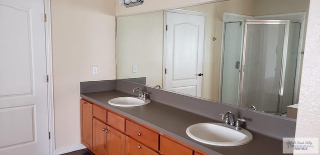 bathroom featuring vanity and a shower with shower door