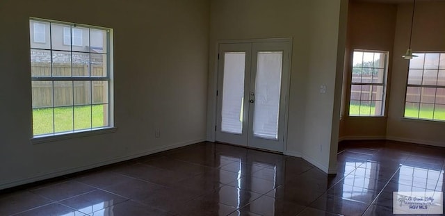 interior space with dark tile patterned flooring and french doors