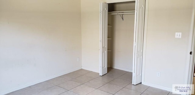 unfurnished bedroom with light tile patterned floors and a closet