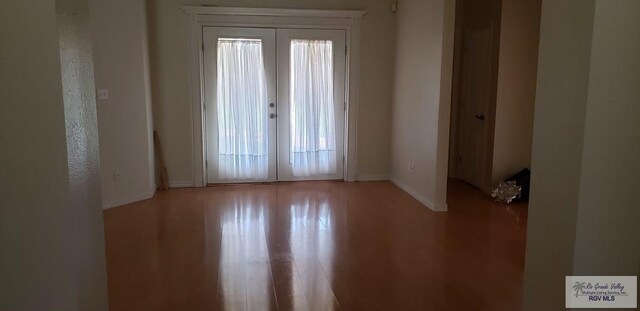 empty room featuring french doors and hardwood / wood-style floors