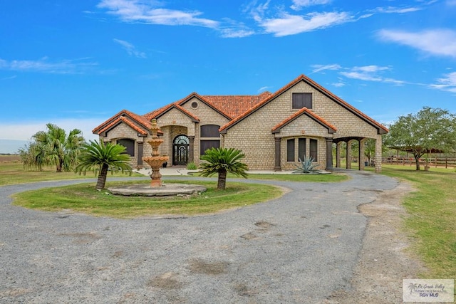 french provincial home featuring aphalt driveway and brick siding