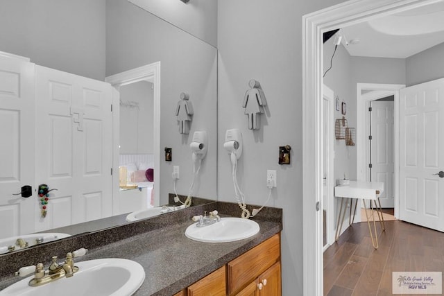 full bathroom featuring double vanity, a sink, and wood finished floors