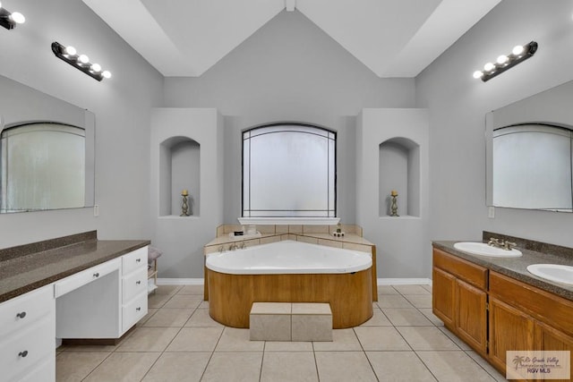 bathroom featuring lofted ceiling, a garden tub, tile patterned flooring, and a sink