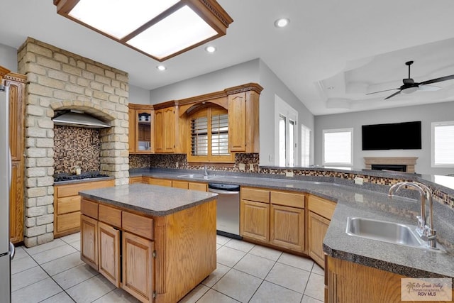 kitchen featuring a sink, dark countertops, decorative backsplash, and dishwasher