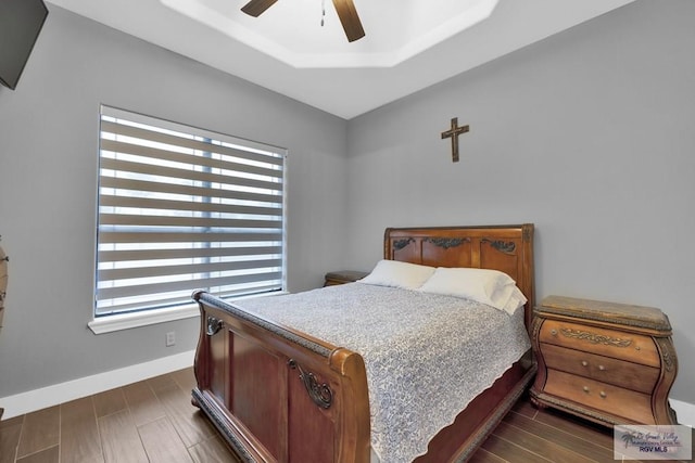 bedroom with dark wood-style floors, ceiling fan, and baseboards