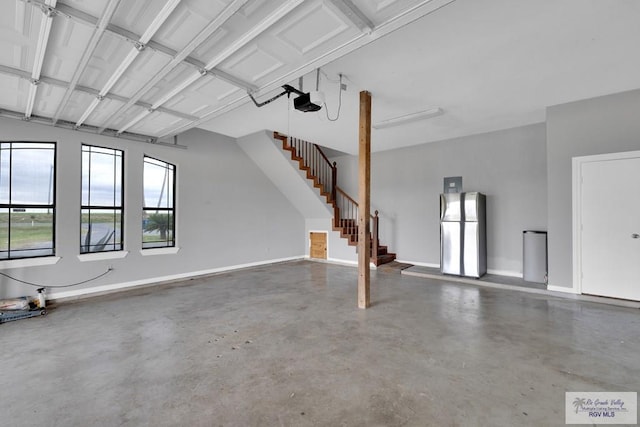 garage with baseboards, freestanding refrigerator, and a garage door opener