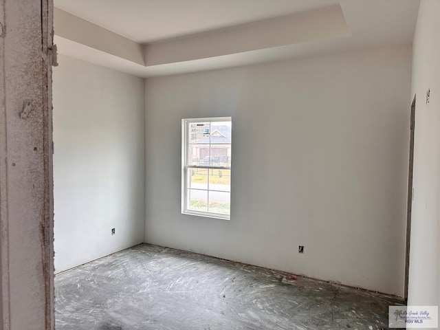 unfurnished room with a tray ceiling