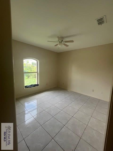 empty room with light tile patterned floors and ceiling fan