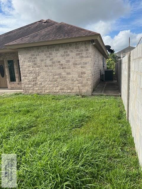 view of home's exterior featuring central AC unit and a yard