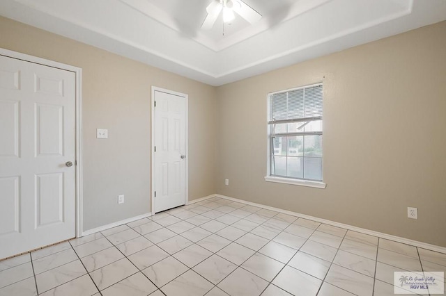 empty room with ceiling fan and light tile patterned floors