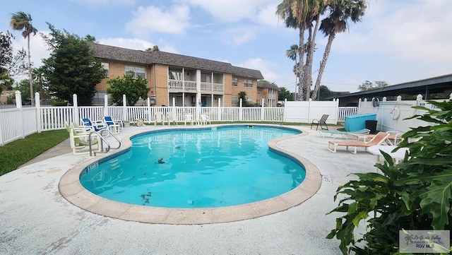 community pool featuring a patio and fence