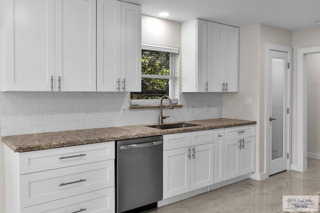 kitchen featuring sink, white cabinetry, dark stone countertops, tasteful backsplash, and stainless steel dishwasher