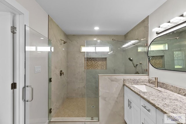 bathroom with vanity and a shower with shower door