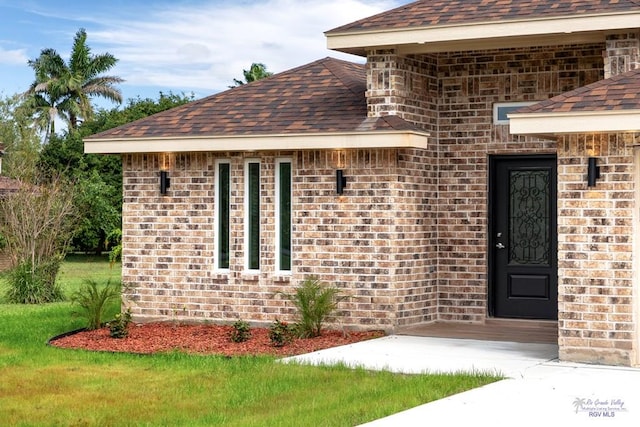 property entrance with a lawn