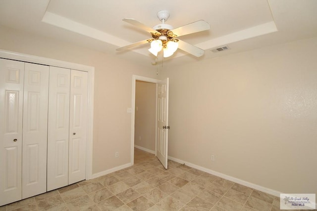 2602 E Mark Cir, Harlingen, TX 78550 - unfurnished bedroom with a tray ceiling, a closet, baseboards, and a ceiling fan