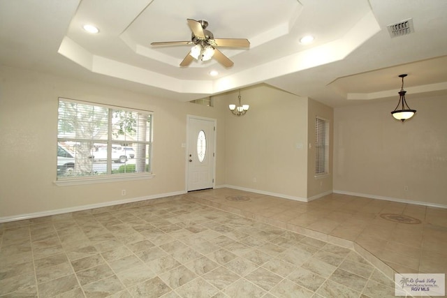2602 E Mark Cir, Harlingen, TX 78550 - entryway featuring a tray ceiling, light tile patterned floors, ceiling fan, recessed lighting, and a chandelier