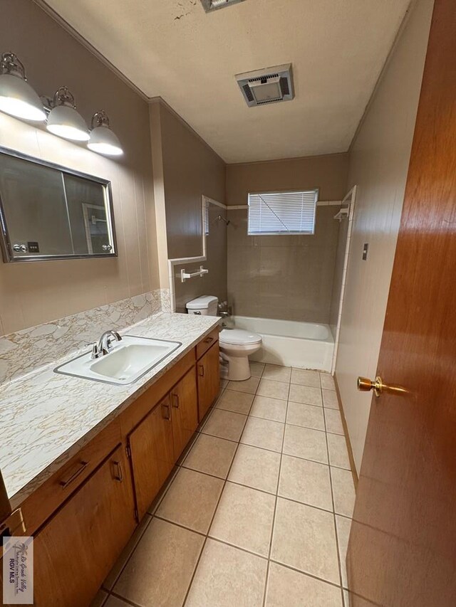 full bathroom featuring tile patterned floors, vanity, toilet, and tiled shower / bath combo