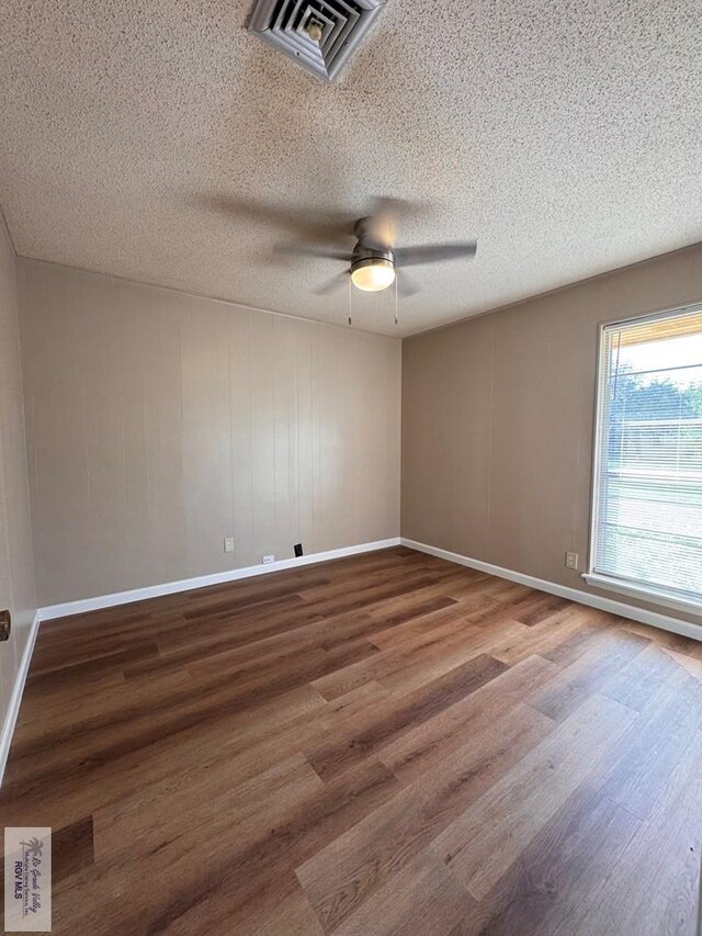 empty room featuring wood-type flooring, a textured ceiling, and ceiling fan