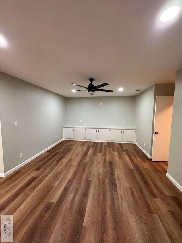 unfurnished living room featuring dark hardwood / wood-style flooring and ceiling fan