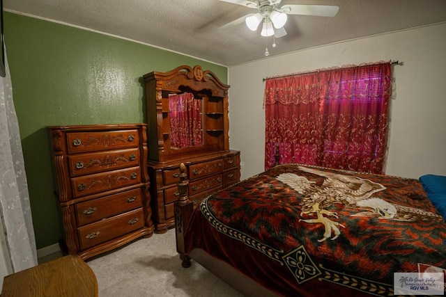 bedroom with ceiling fan, light colored carpet, and a textured ceiling