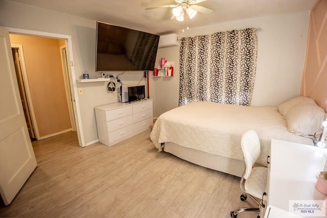 bedroom featuring ceiling fan, light wood-type flooring, and an AC wall unit