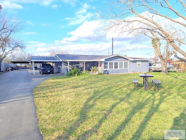 ranch-style house featuring a carport and a front yard