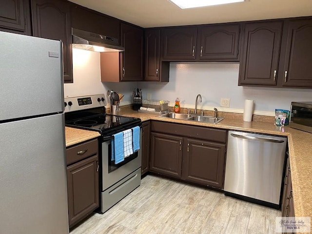 2010 El Dorado Ave, Rancho Viejo, TX 78575 - kitchen featuring appliances with stainless steel finishes, under cabinet range hood, a sink, light wood finished floors, and light countertops