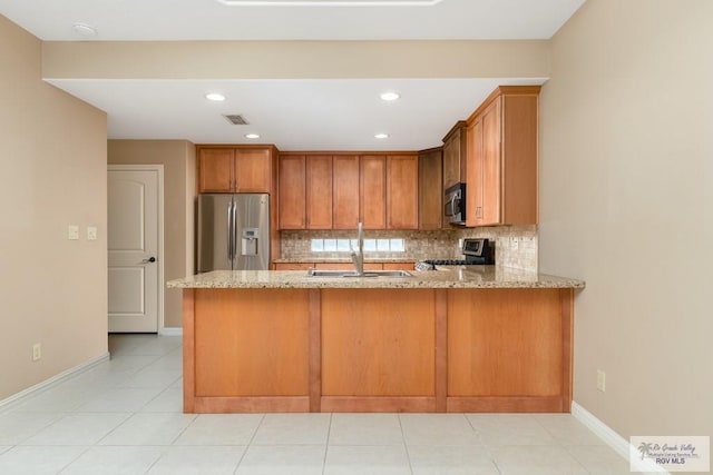 kitchen featuring stainless steel appliances, light stone countertops, and kitchen peninsula