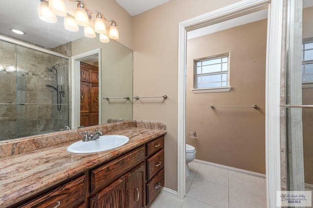 bathroom featuring tile patterned flooring, vanity, toilet, and an enclosed shower