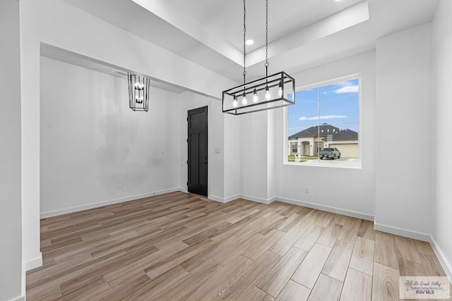 unfurnished dining area featuring a tray ceiling