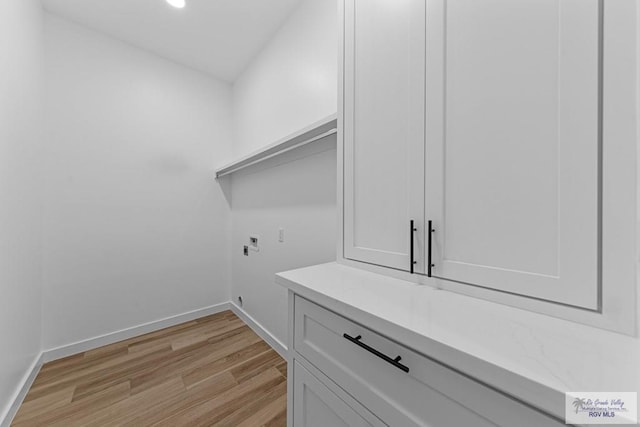 laundry room with electric dryer hookup, hookup for a washing machine, cabinets, and light wood-type flooring