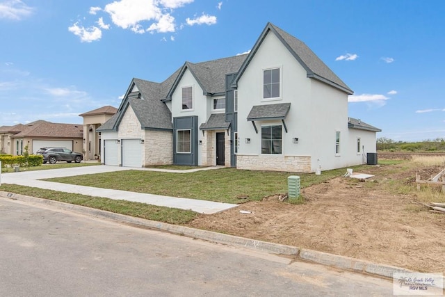 view of front of property with a front lawn, central AC unit, and a garage