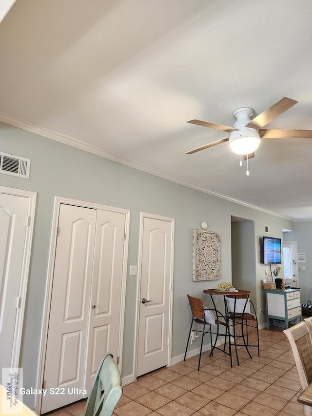 tiled dining room featuring ceiling fan and ornamental molding